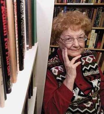 A picture of Andre Norton standing in her library.
